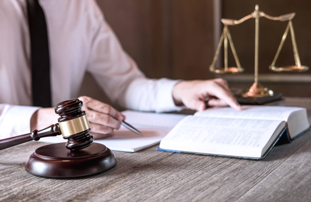 male-lawyer-or-judge-working-with-law-books-1-e1743869605452.jpg